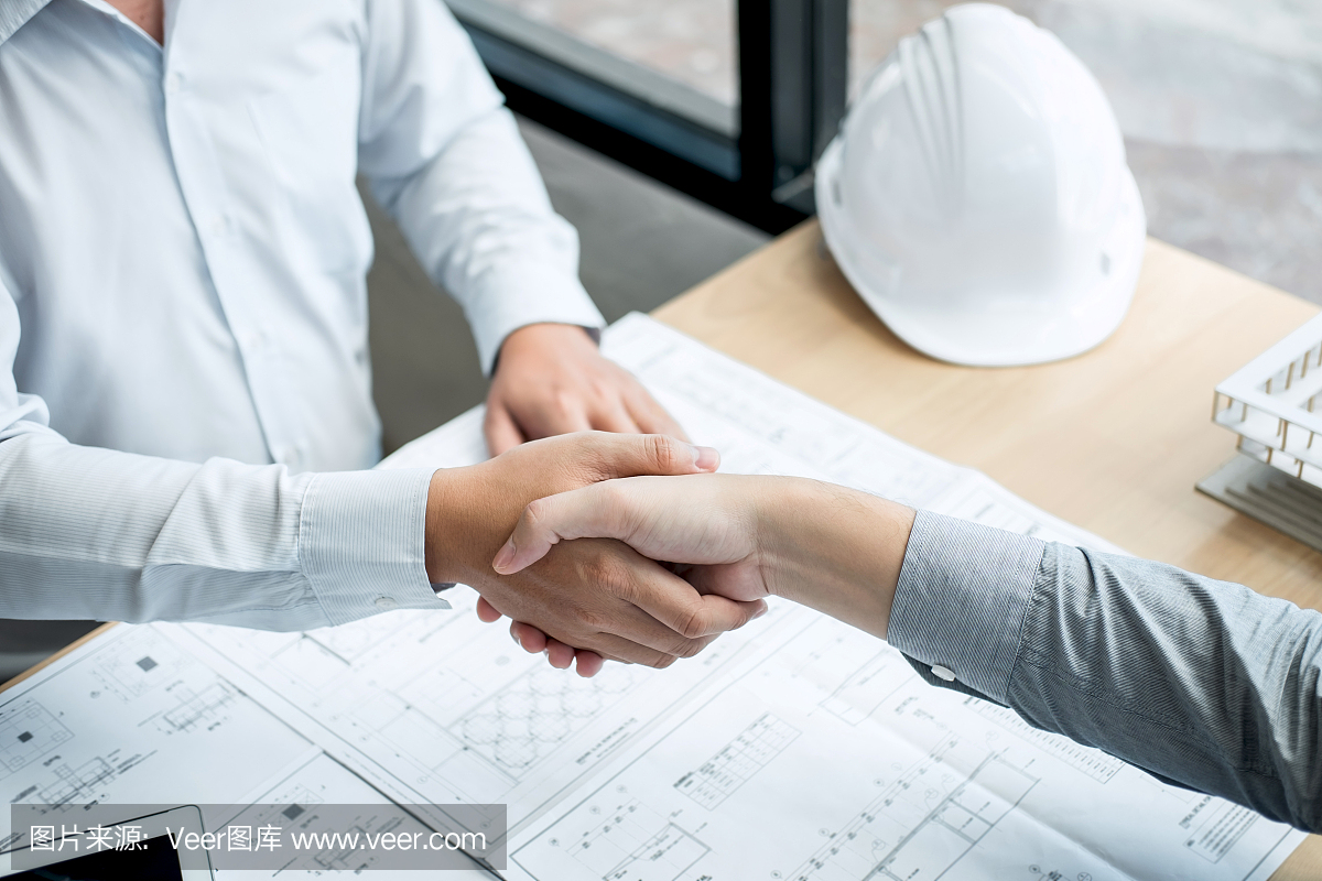 合作伙伴握手,建筑工程或建筑師討論藍(lán)圖和建筑模型,同時(shí)檢查草圖信息,為建筑項(xiàng)目的合作伙伴舉行會(huì)議