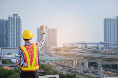 工程師或建筑師與防護安全帽檢查建筑圖紙呼叫支持團隊在建筑工地。工程建筑和建筑施工理念。軟焦點